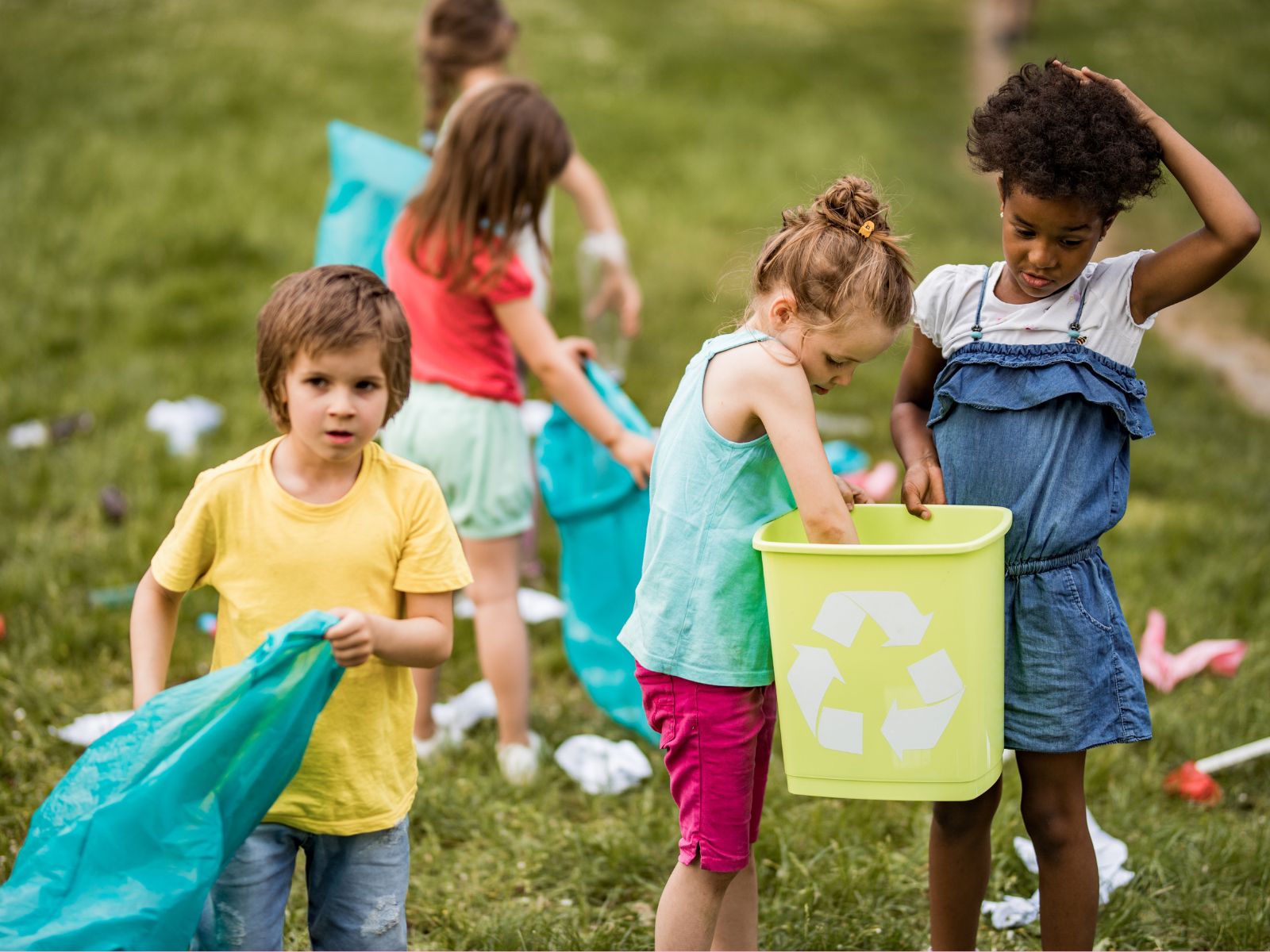 A group of children picking up litter outside.