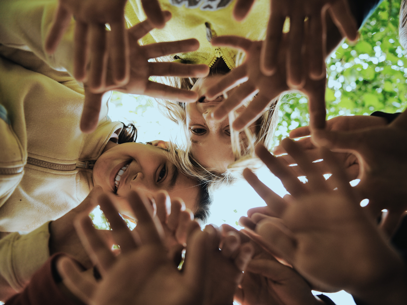 A bunch of kids hunched over directly over a camera