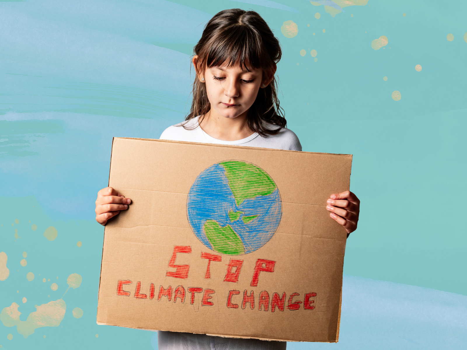 A kid holding a placard that says STOP CLIMATE CHANGE