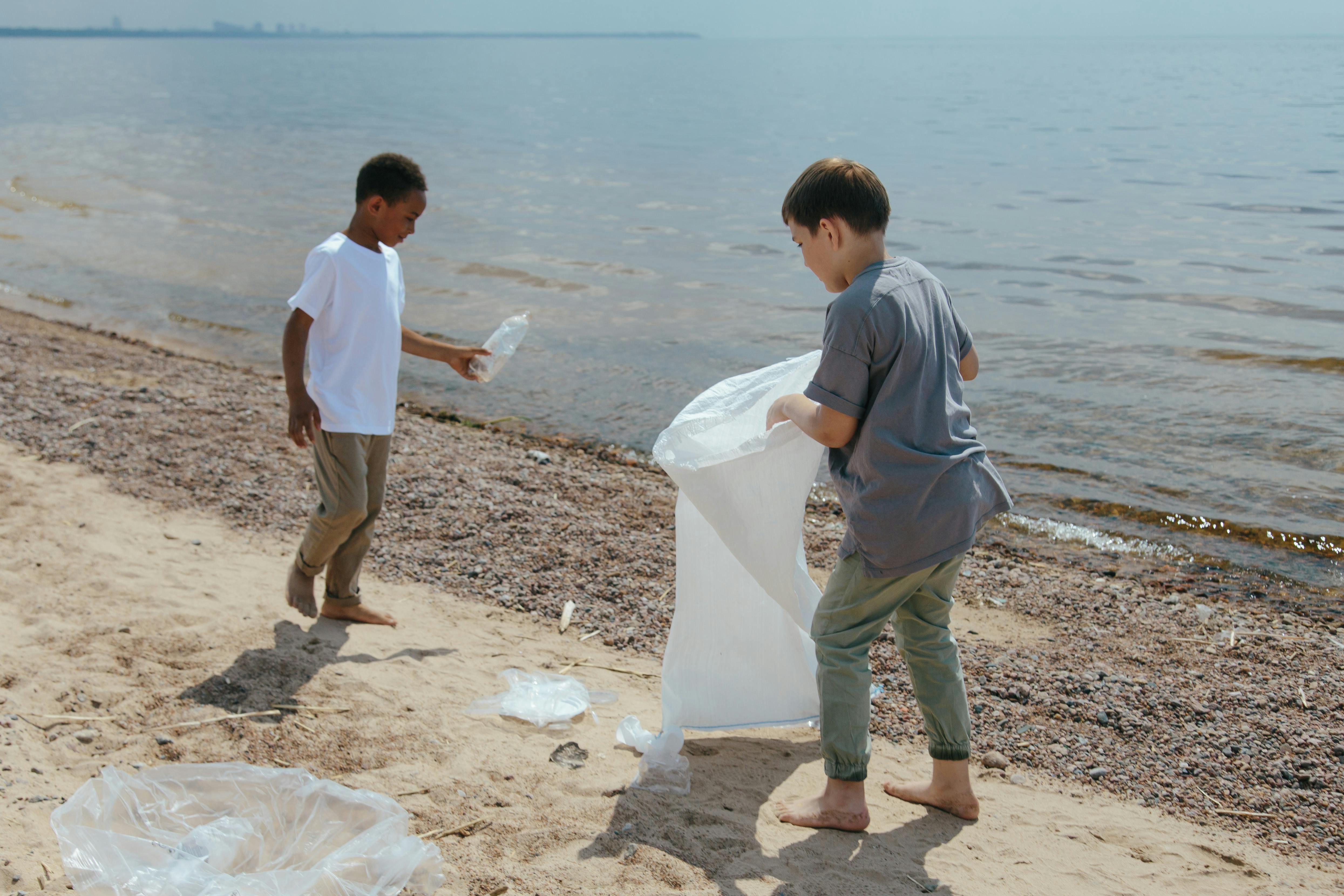 A couple of kids picking up rubbish on the beach